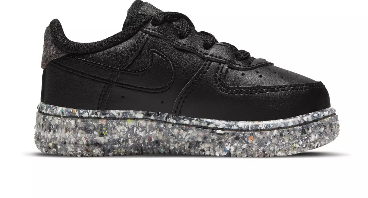 Toddler black low-top sneakers with swoosh and speckled sole, lace-up design
