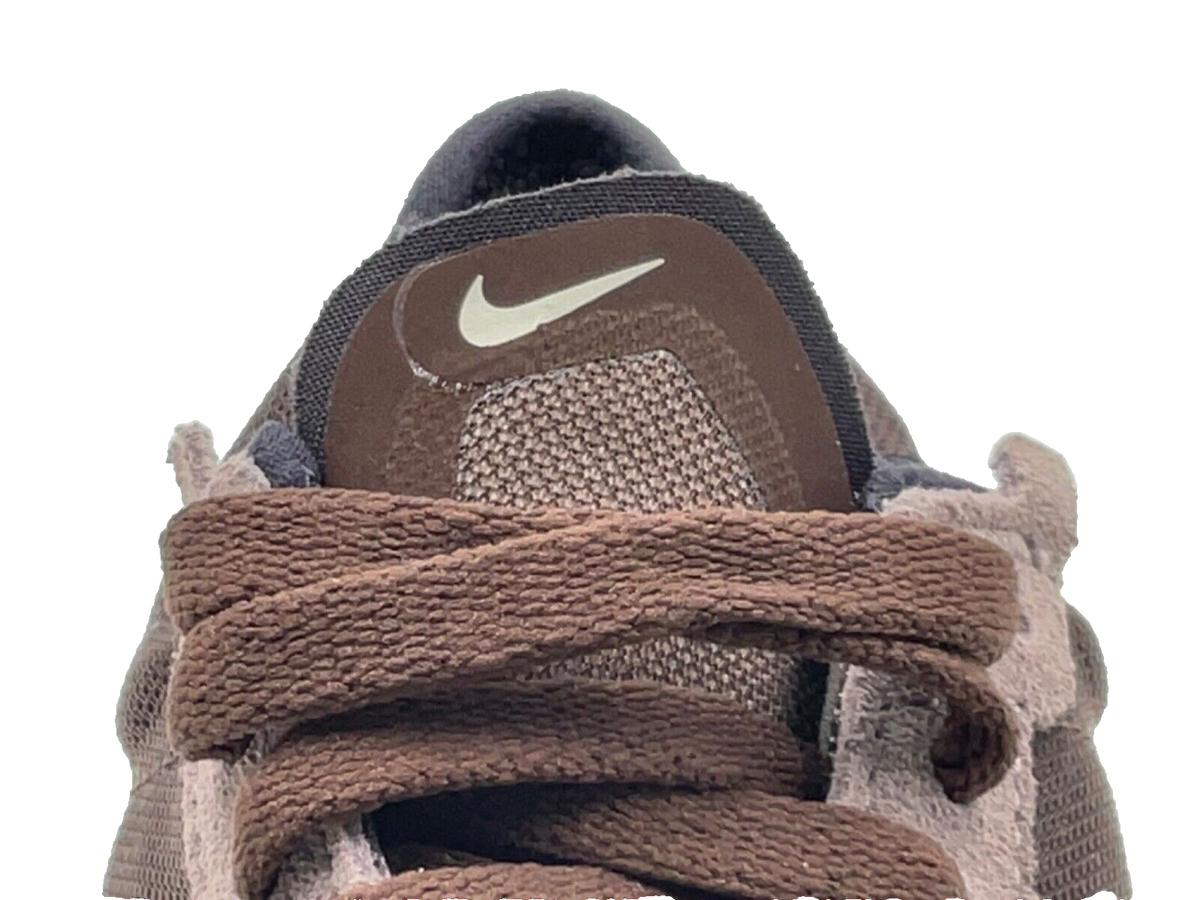 Nike Waffle One sneaker heel, brown pull tab and swoosh mark on dark upper