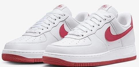 Nike Air Force 1 low-top sneakers, pair view; white leather with pink swooshes and red soles.
