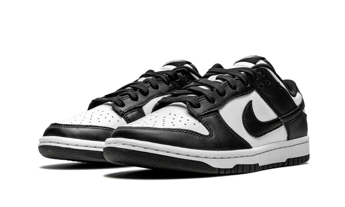Nike Dunk Low sneakers, side view, black panels with white toe and perforations