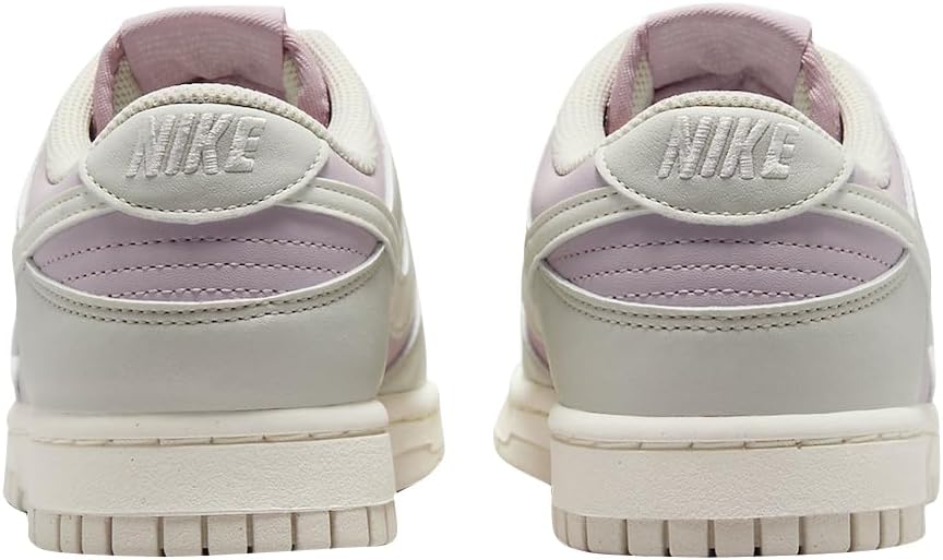 Women's Nike Dunk Low sneakers, rear view in light bone with lilac collar and swoosh.