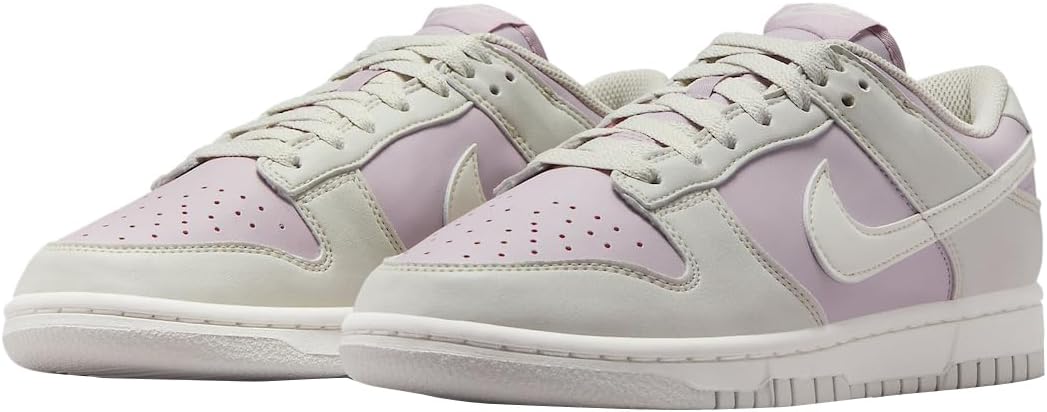 Pair of Women's Nike Dunk Low sneakers, light bone uppers with lilac side panels.