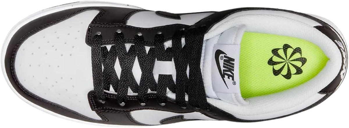 Toe of a white-and-black low-top sneaker with black laces and neon green insole