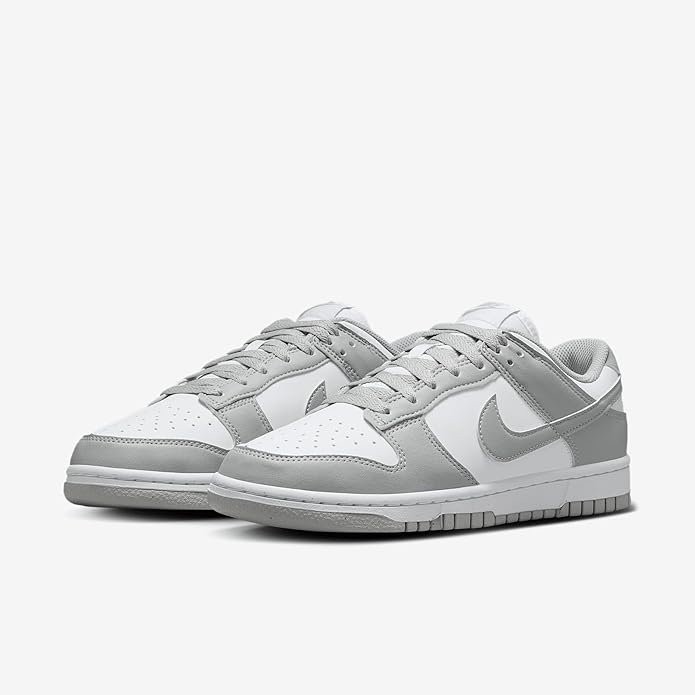 Pair of white and light gray Nike Dunk Low low-top sneakers, lace-up.