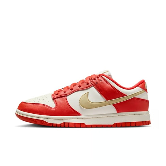 Low-top Nike Dunk sneakers with red leather panels, gold swoosh, and white base
