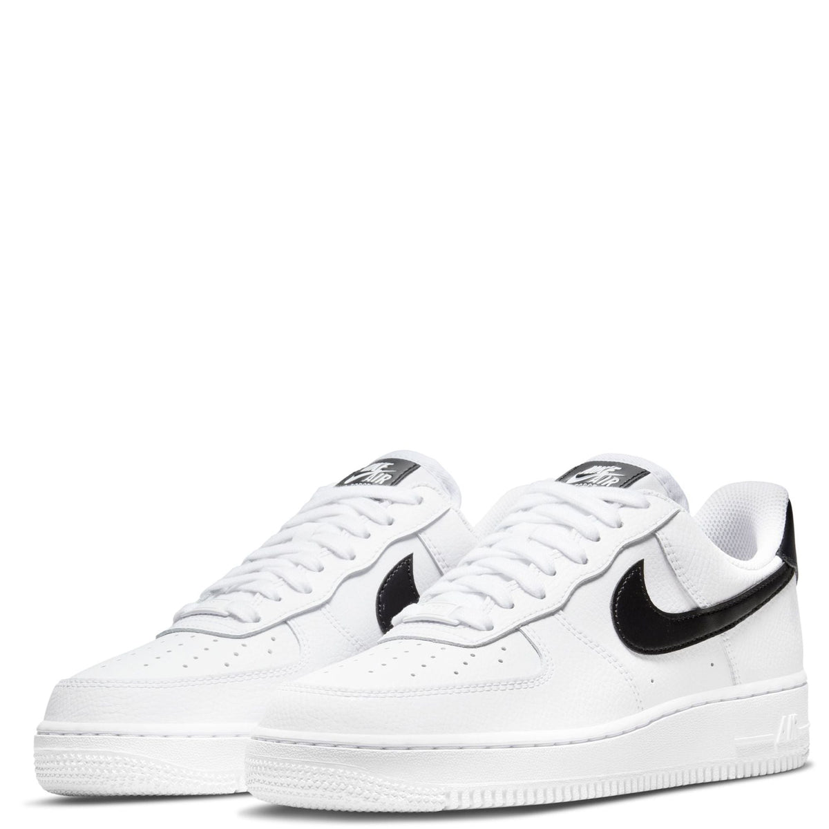 Pair of white Nike low-top sneakers with black swooshes and white laces.