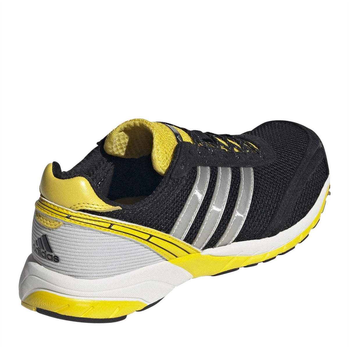 Black low-top sneakers with yellow heel collar, silver stripes, and white midsole