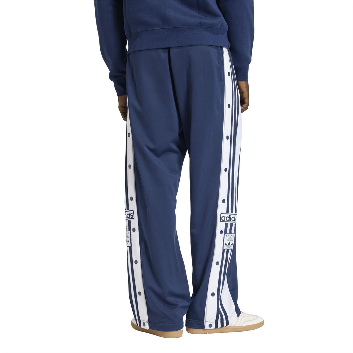 Men's indigo track joggers with full-length side stripe and snap-button detailing