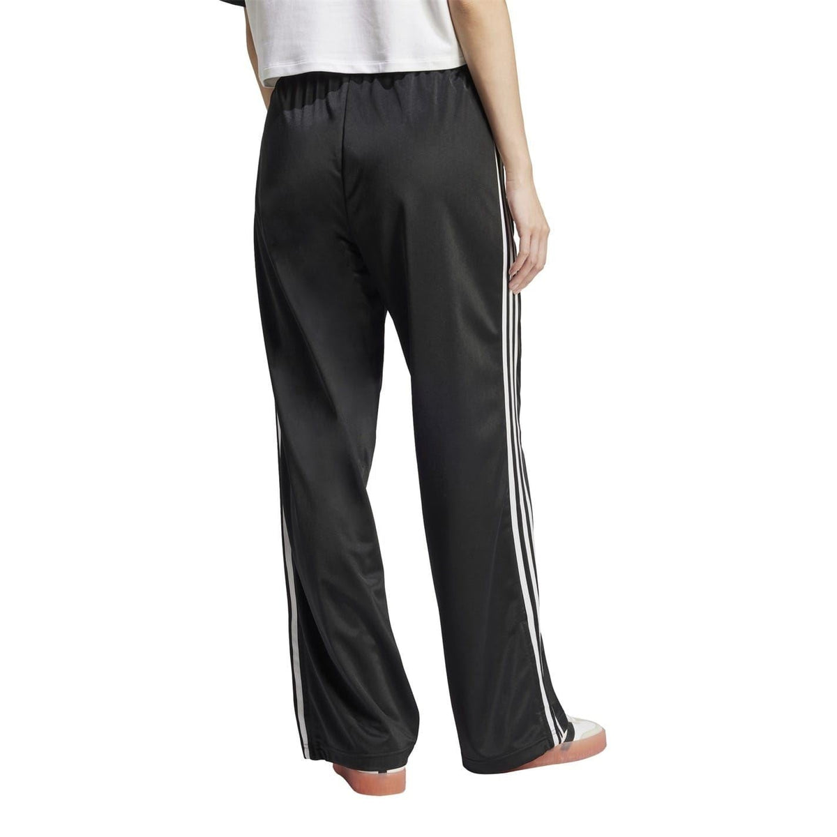 adidas Originals loose black track pants with white side stripes, full-length legs, elastic waist