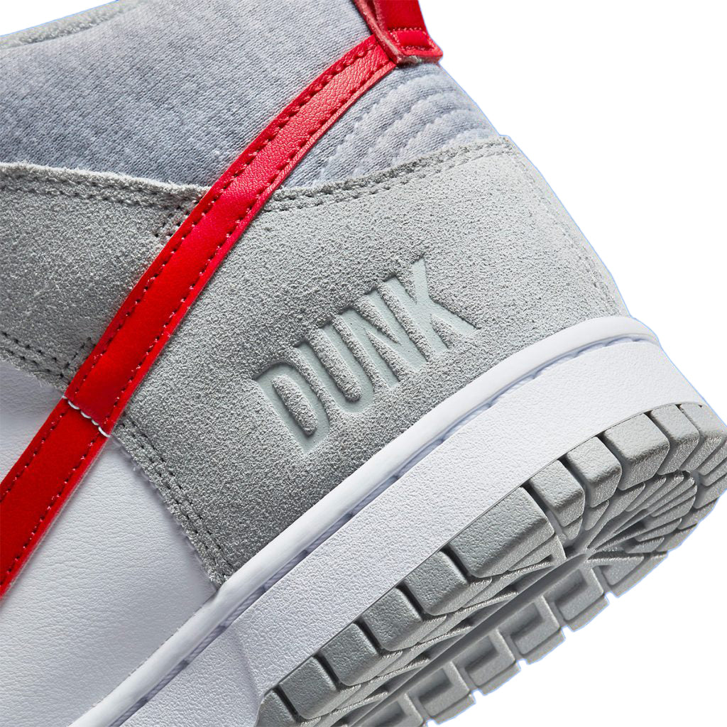 Kids' high-top sneaker detail with embossed 'DUNK' on grey strap and red trim.