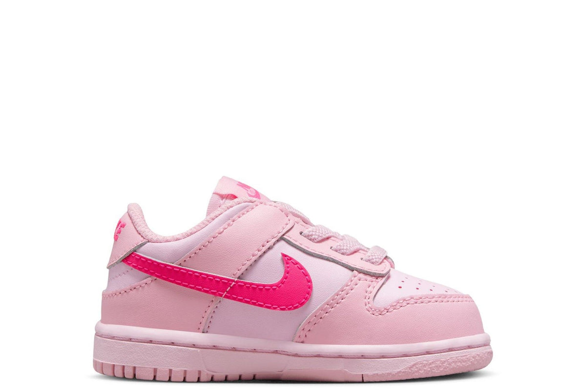 Kids' Nike Dunk Low sneakers, light pink leather with hot pink swoosh stripe.