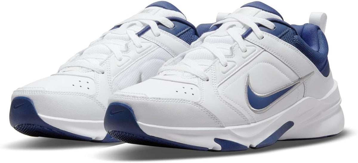 Pair of white Nike Defy All Day sneakers with navy accents and swoosh logos