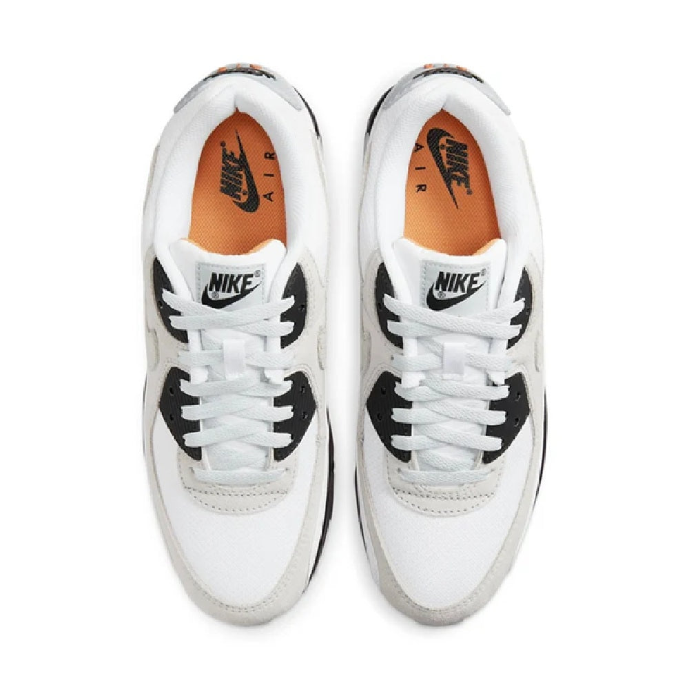 White sneakers with laced front and black heel overlays, orange lining inside