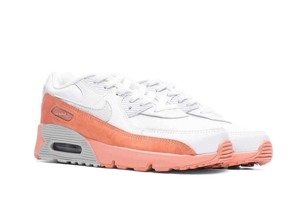 Kids' Nike Air Max 90 sneaker side view, white upper with orange trim and foam sole