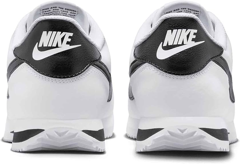 White low-top sneakers with black heel overlays, Nike branding, and cushioned sole