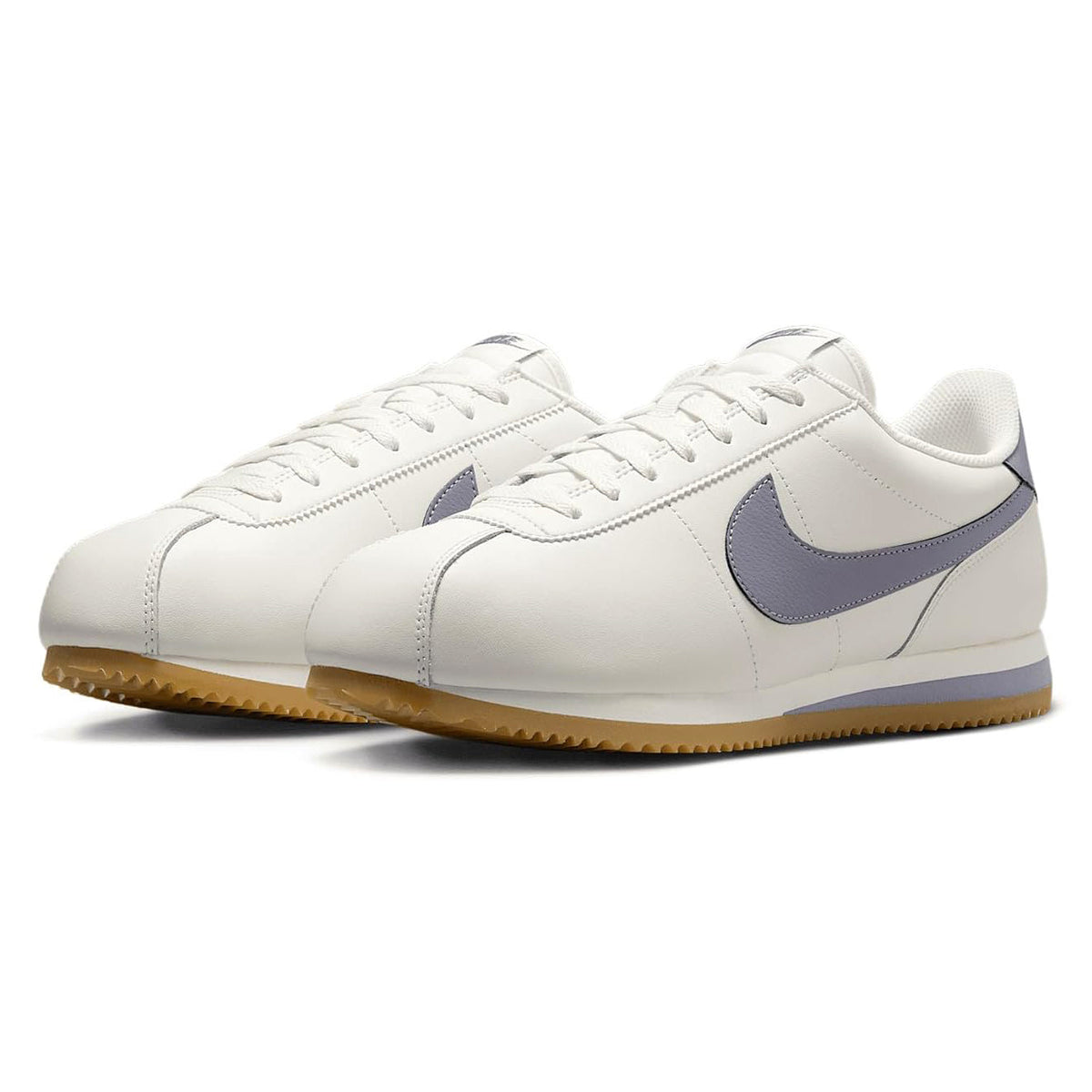 Men's Nike Cortez sneakers with white uppers, navy side panels, and gum outsole.