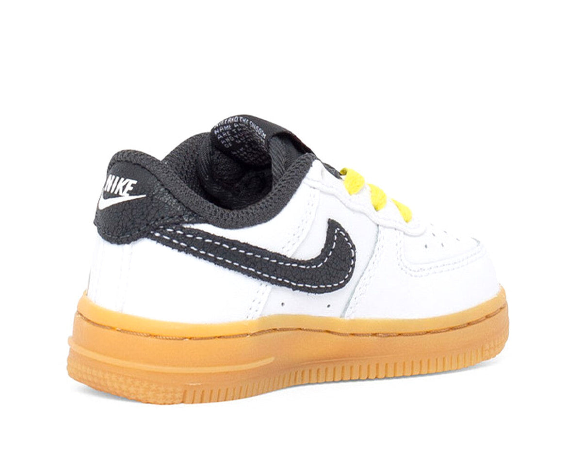 Kids low-top sneakers, white leather with black heel panel, yellow laces, gum outsole