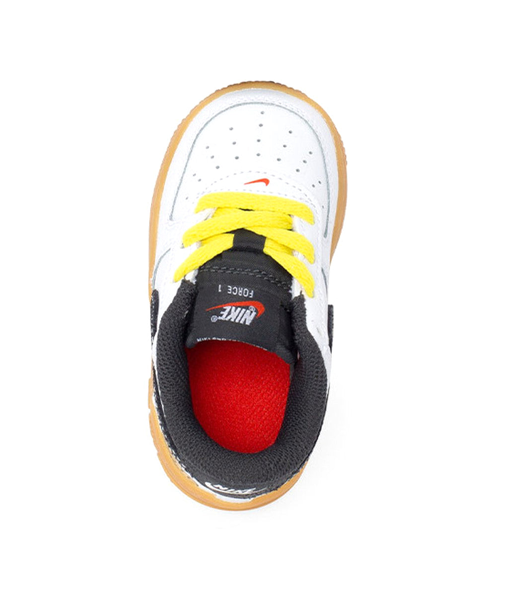 Low-top sneakers with yellow laces, white leather, black collar, and red inner lining