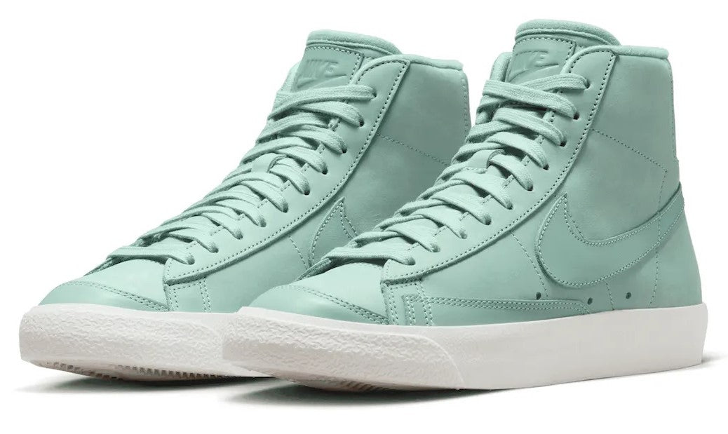 Pair of mint Nike high-top sneakers with lace-up fronts and white soles