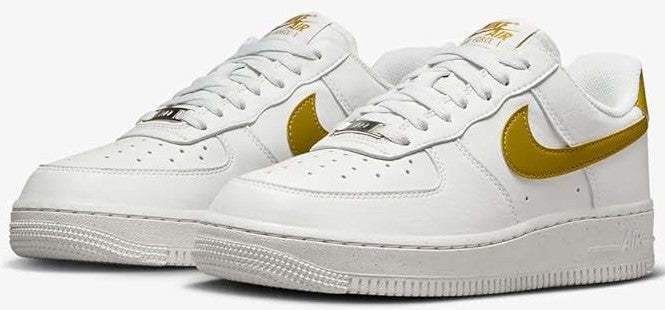 Pair of white low-top Nike Air Force 1 sneakers with gold Swoosh and laces