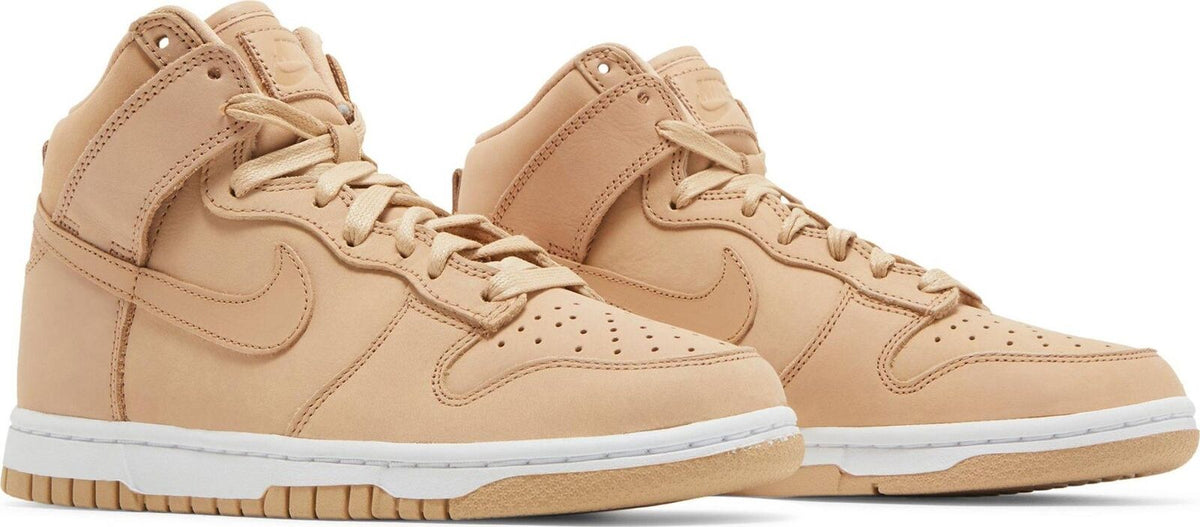 Pair of women's tan Nike Dunk high-top sneakers, lace-up design with padded collars
