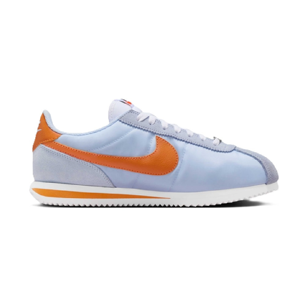 Nike Cortez sneakers, side view in light blue with orange Swoosh and white midsole