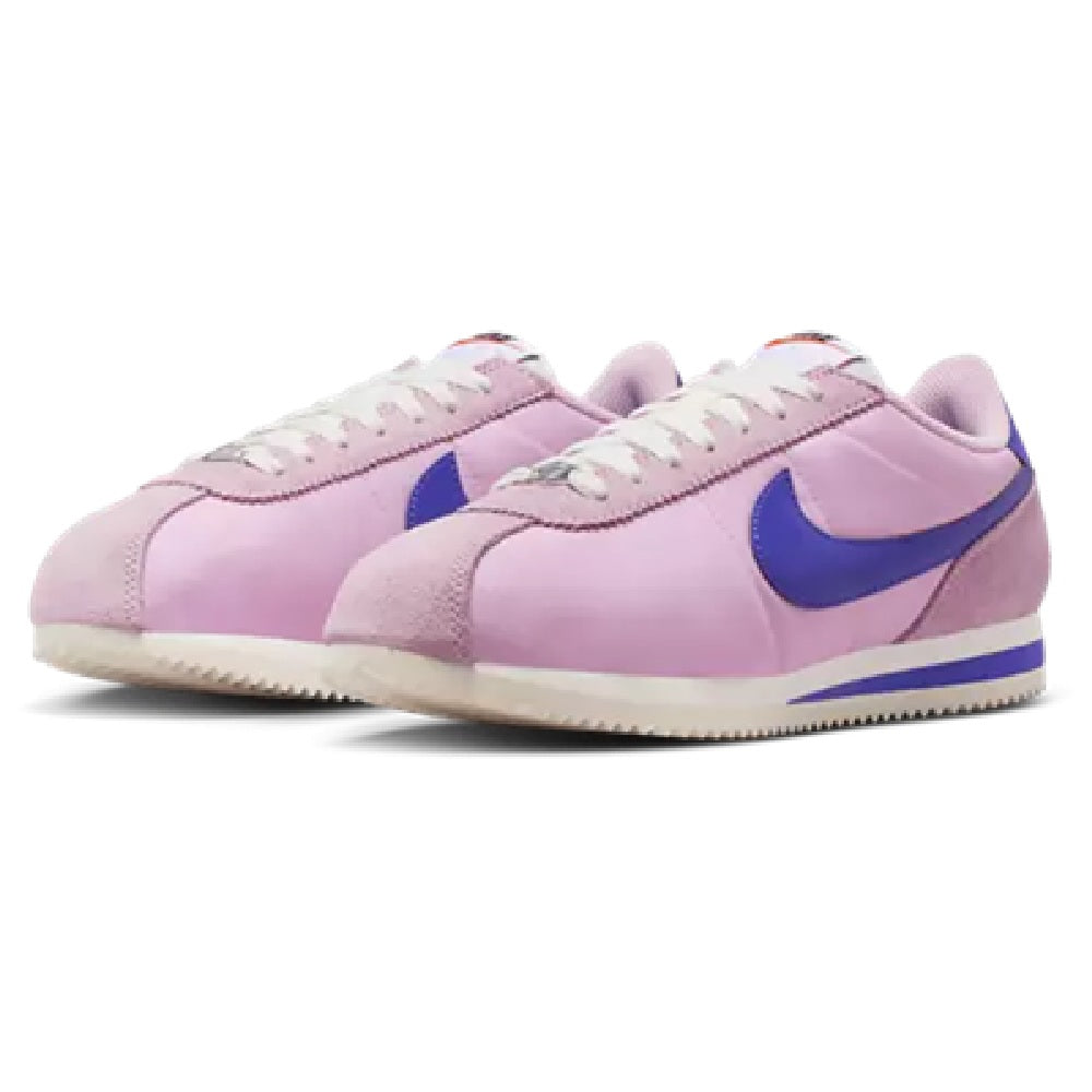 Pair of women's Nike Cortez LT sneakers, light pink uppers with blue accents.