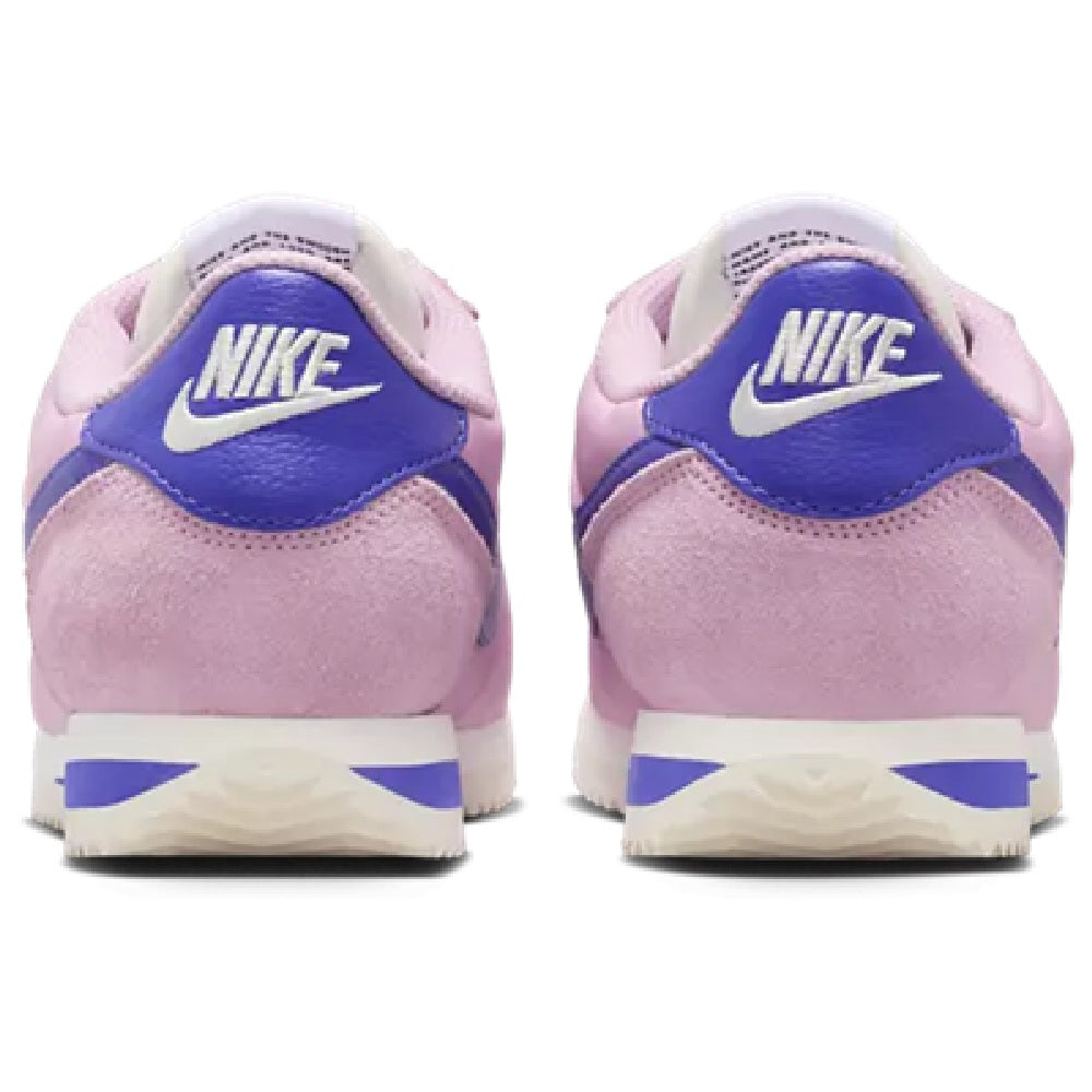 Women's Nike Cortez LT heel view, pink suede with blue NIKE branding and white midsole.
