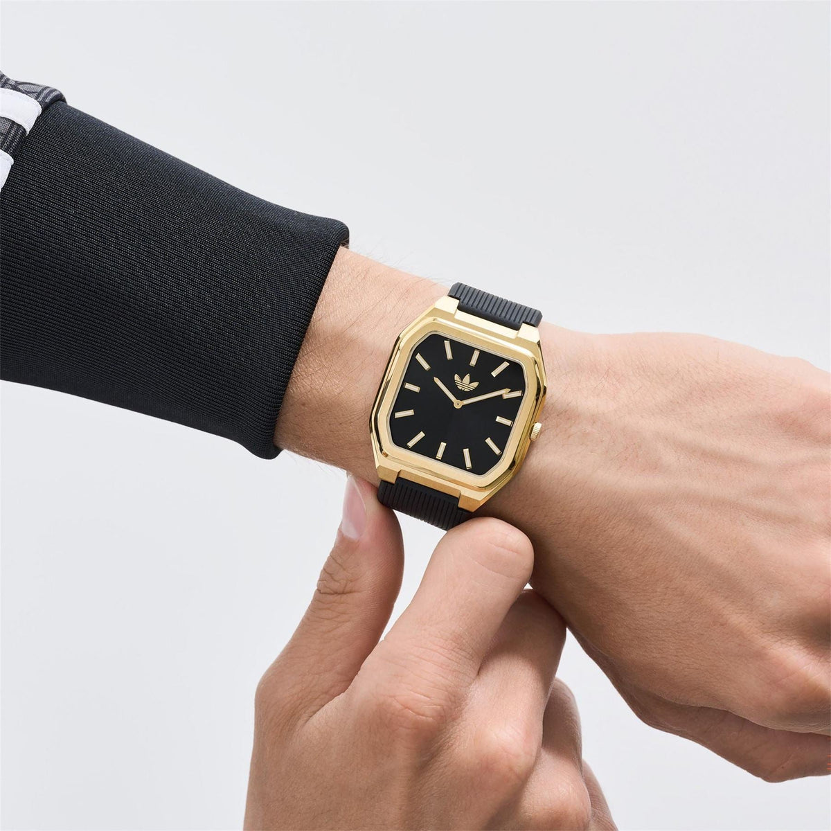adidas Originals wrist watch, black dial, gold-tone case, black ridged strap detail view