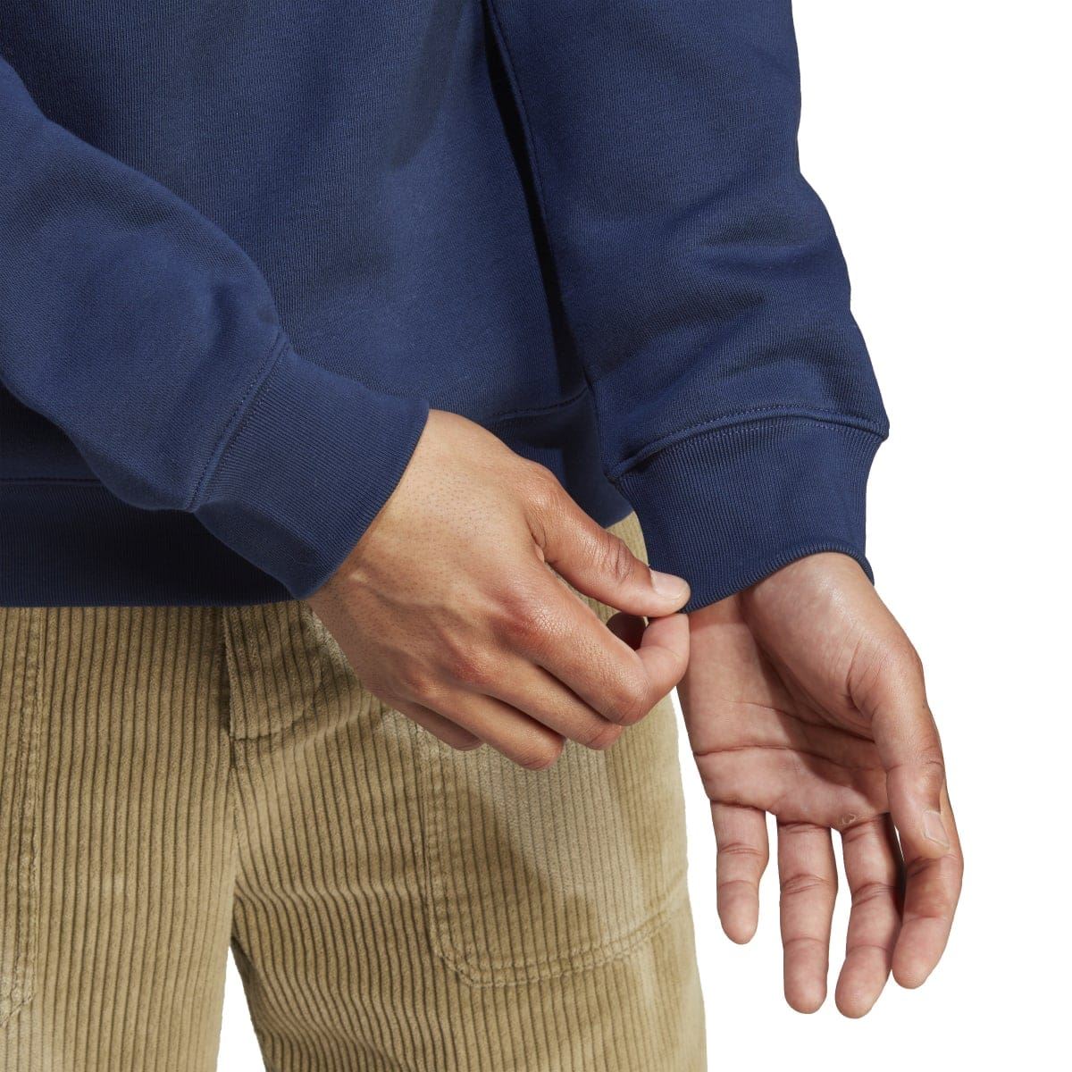 Navy sweatshirt sleeve and rib cuff, hands visible with tan pants