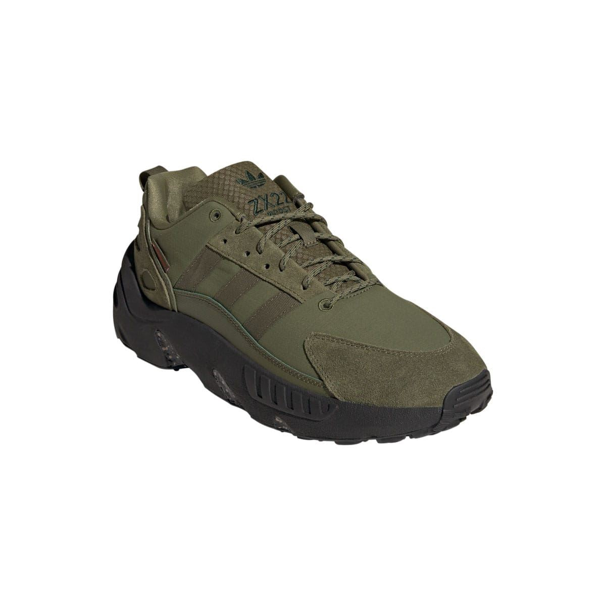 Olive lace-up trainers with textured side panels and dark rugged outsole