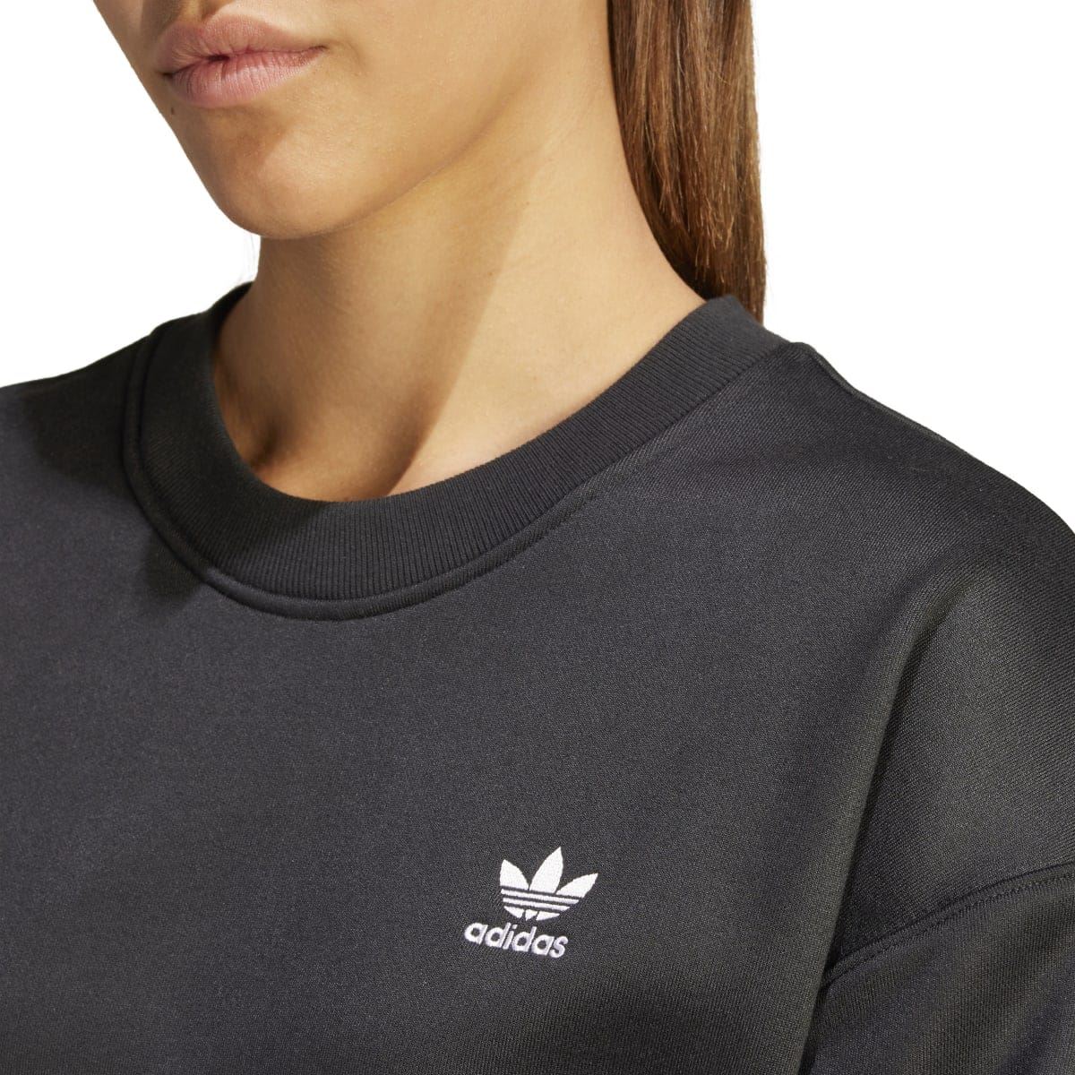 Close-up of black crew sweatshirt neckline with small adidas trefoil logo