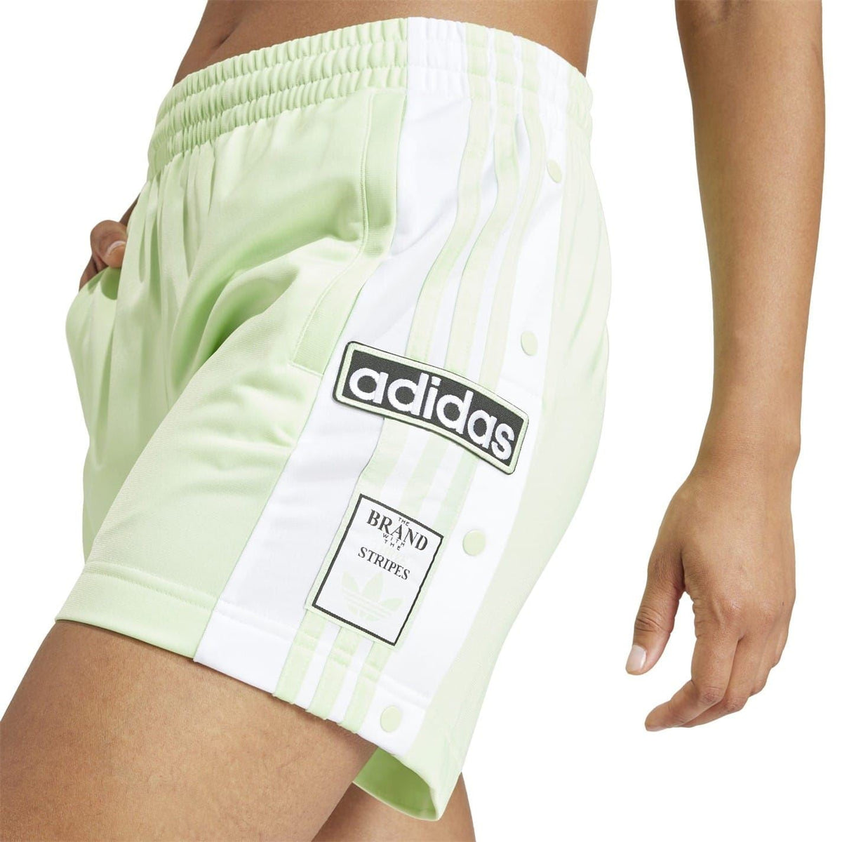 Light green Bermuda shorts with adidas logo patch and white striped side panel