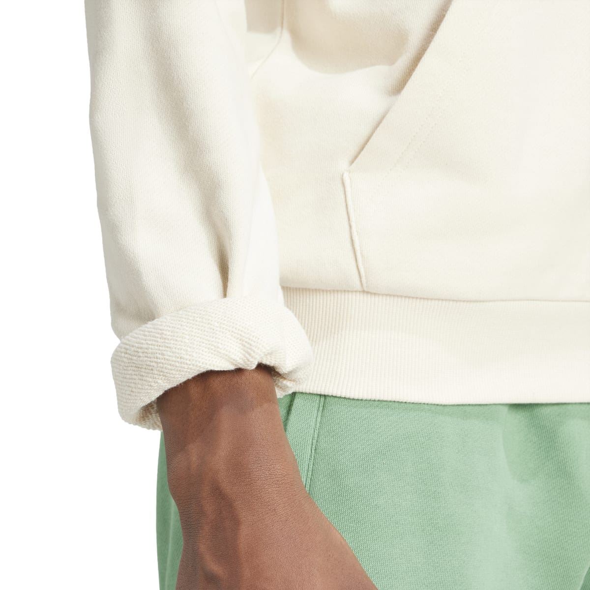 Cream hoodie sleeve cuff and hem detail with drawcords; trefoil logo visible