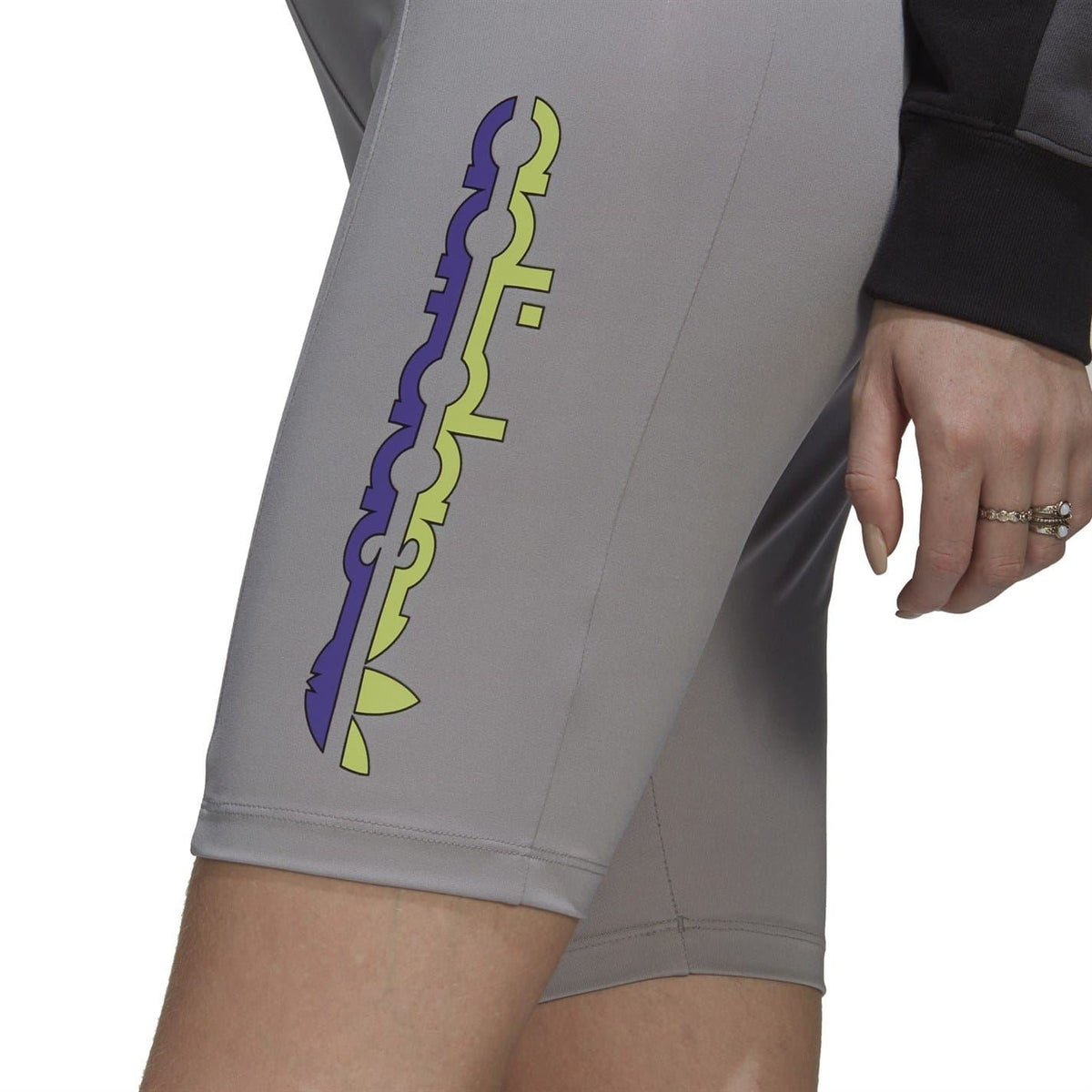 Close-up of light gray short leggings with colorful vertical logo print