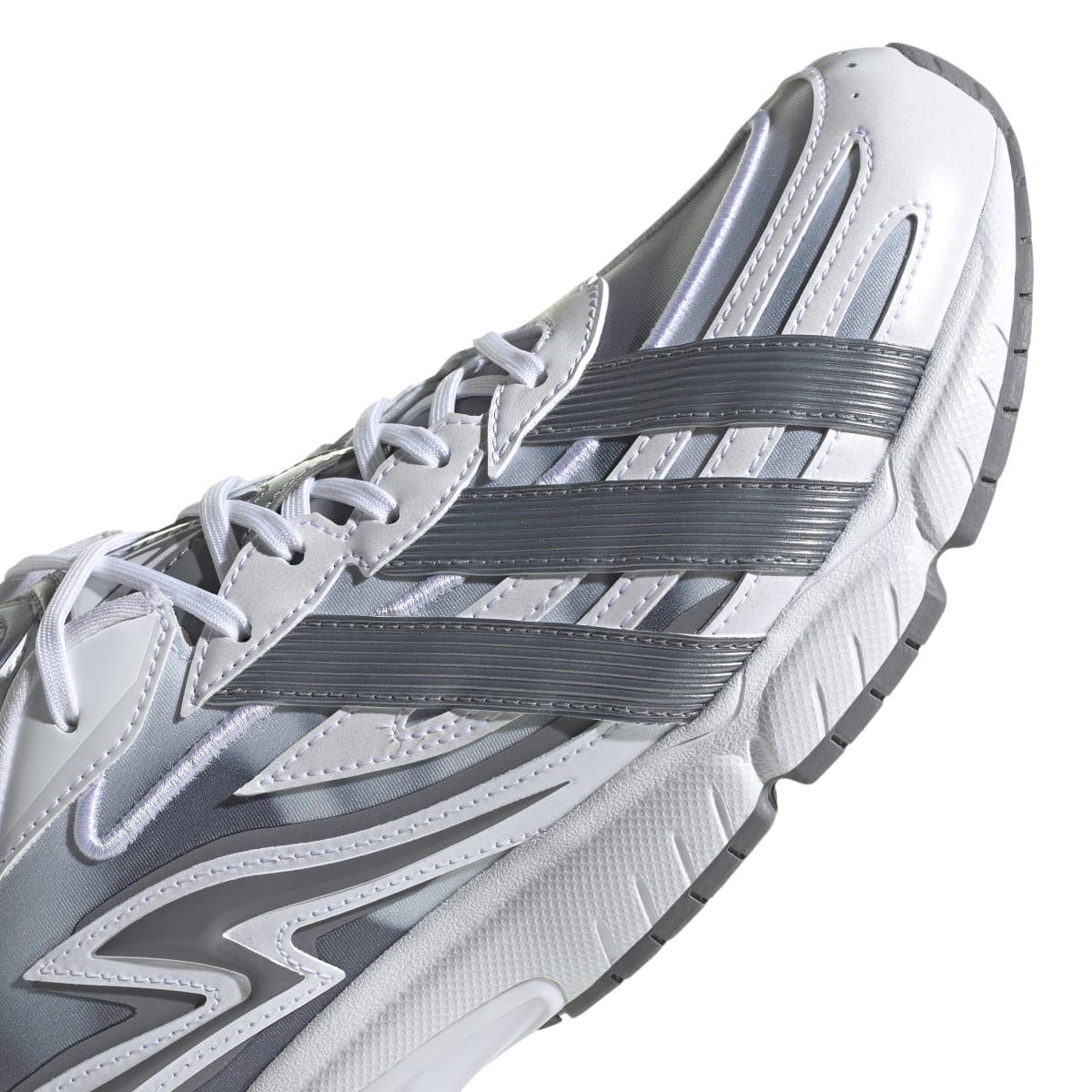 White and grey sneaker close-up of side panel with stripes and zigzag logo