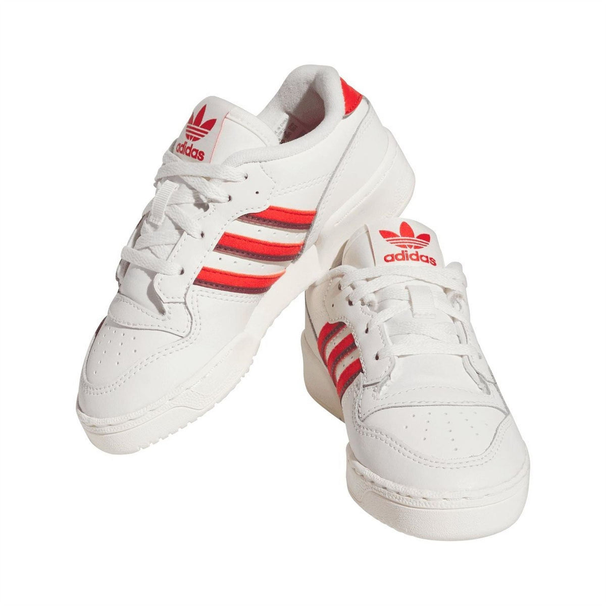 White low-top trainers with red stripe accents, heel pull tab, and adidas tongue logo