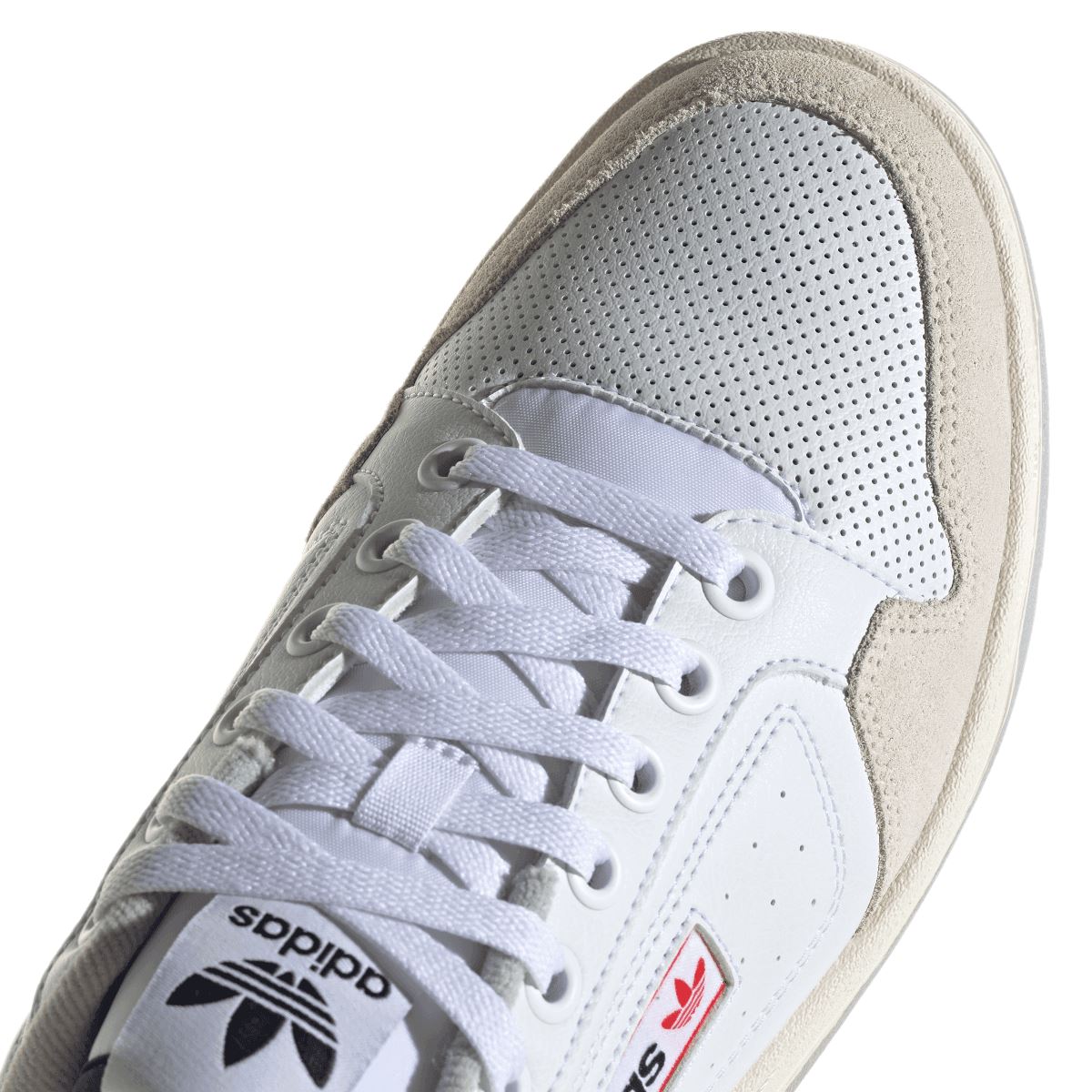 Close-up of white adidas NY 90 upper with perforated paneling and lace eyelets.