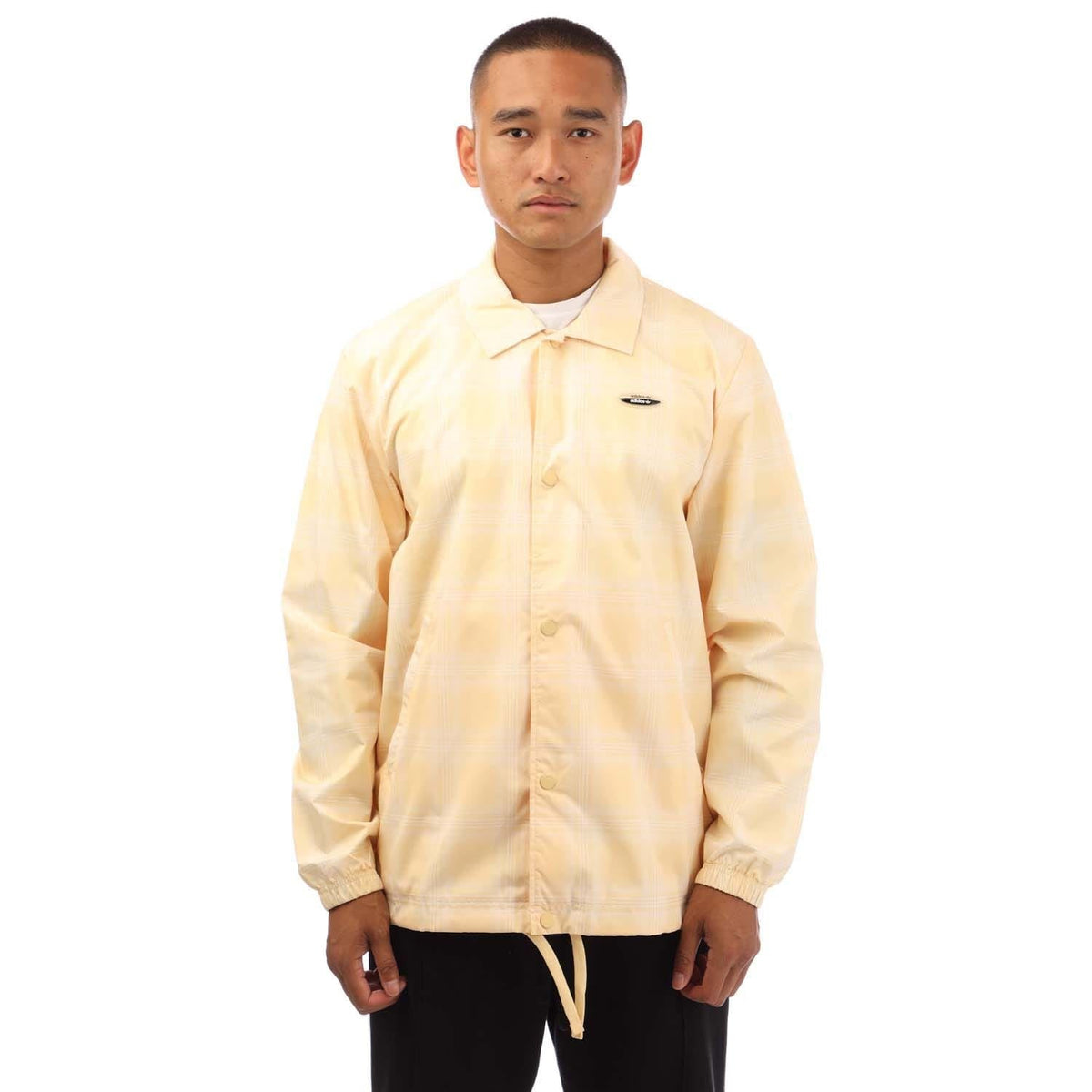 light yellow coach jacket with stand collar, button front, and elastic drawstring hem