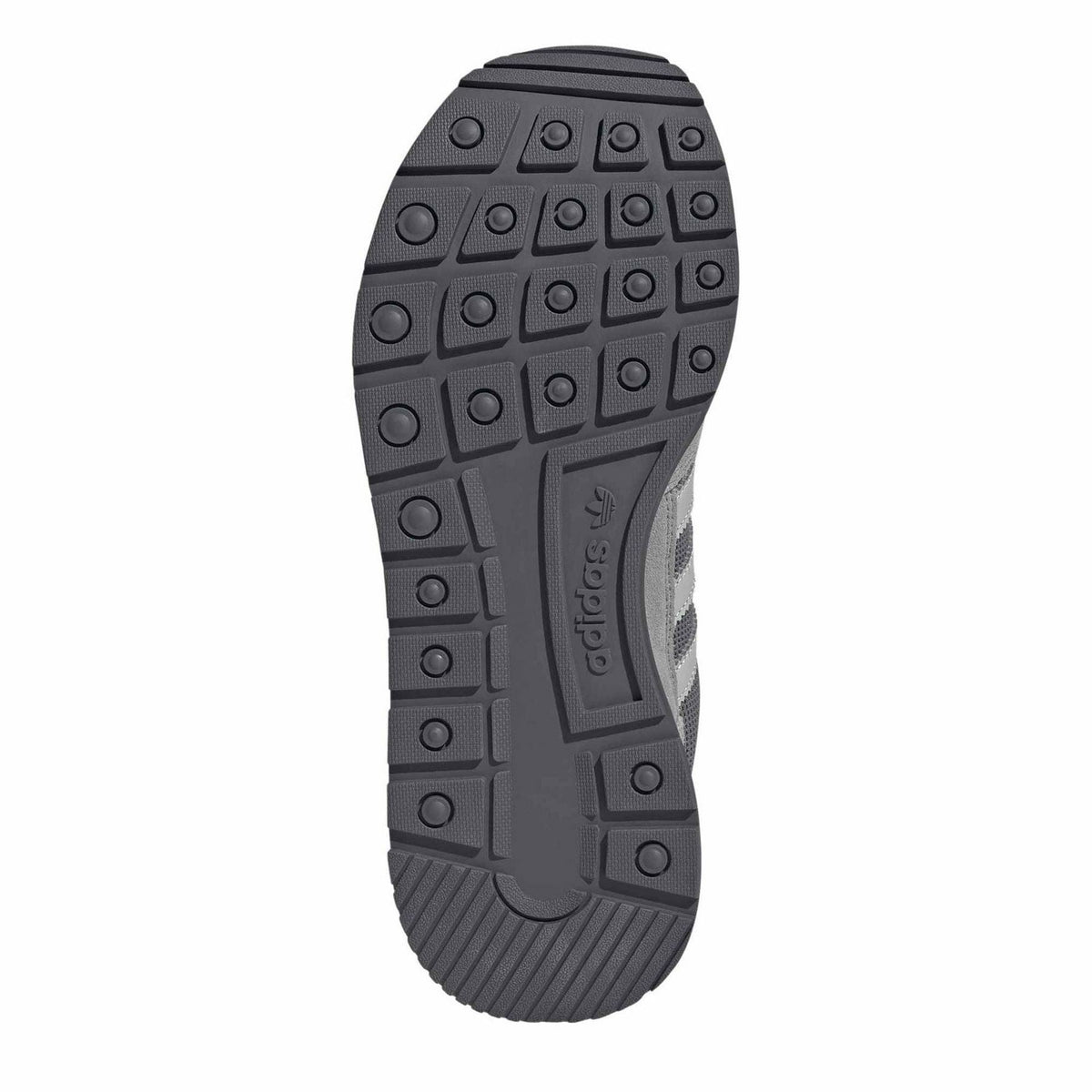 Grey outsole tread with circular traction nubs under sneaker
