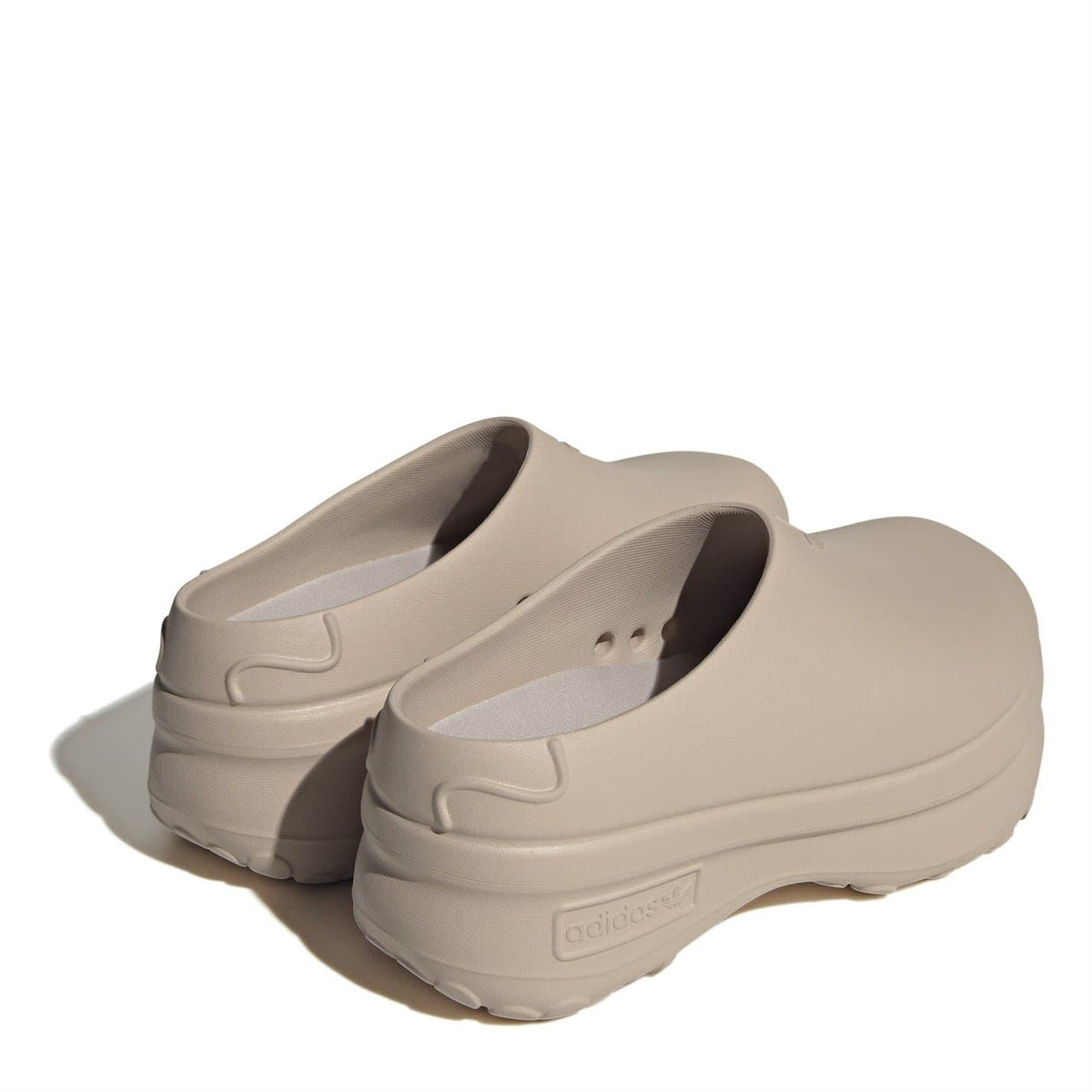 Beige low-top trainers, pair shown from rear and side with molded heel and strap detail