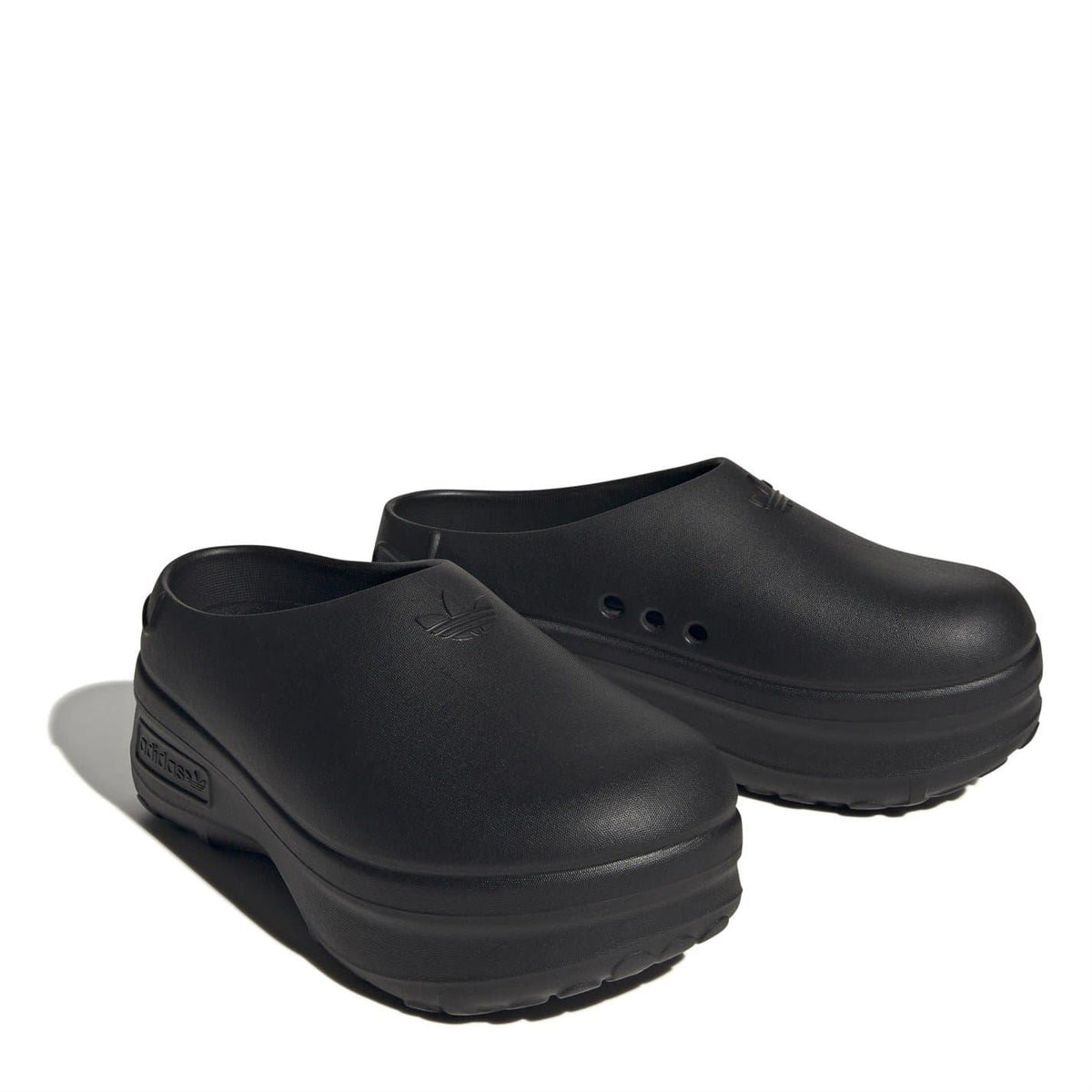 Black low-top slip-on trainers, pair shown at angle with embossed side logo on back