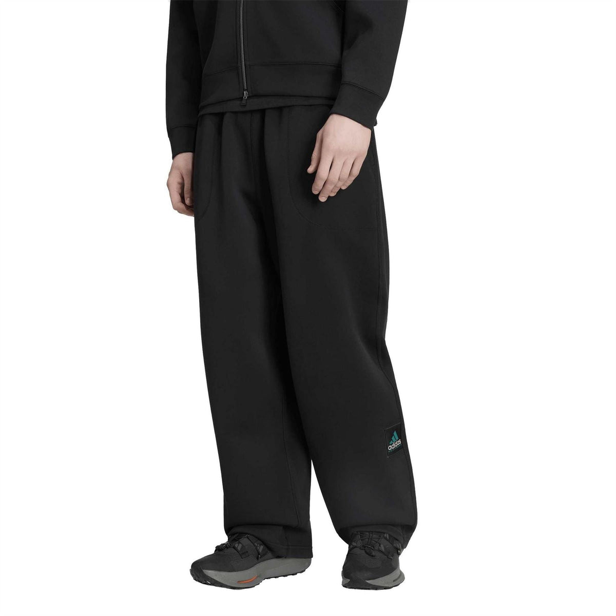 Black EQT track pants with relaxed fit, side pockets, and small leg logo