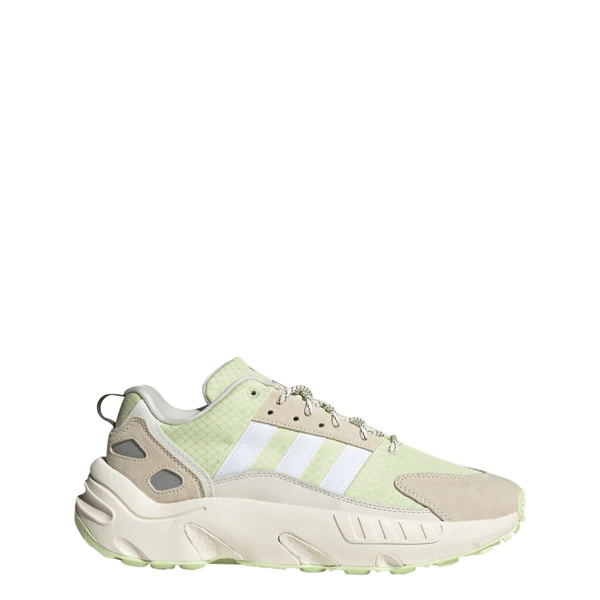 Off white low-top trainers with light green mesh panels, white stripes, and lace-up front