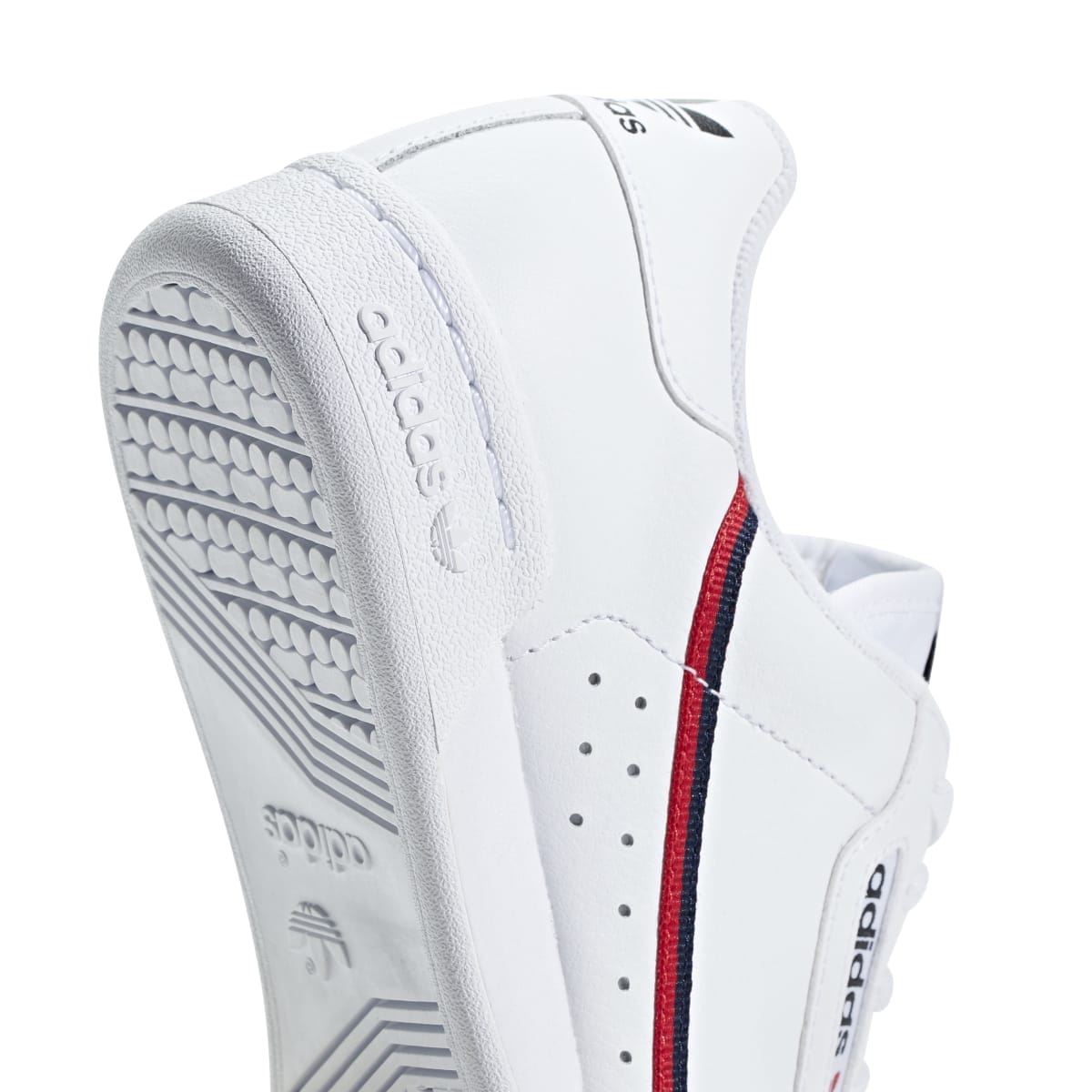 White Adidas Continental 80 junior shoe heel and side, with red-and-navy stripe detail.