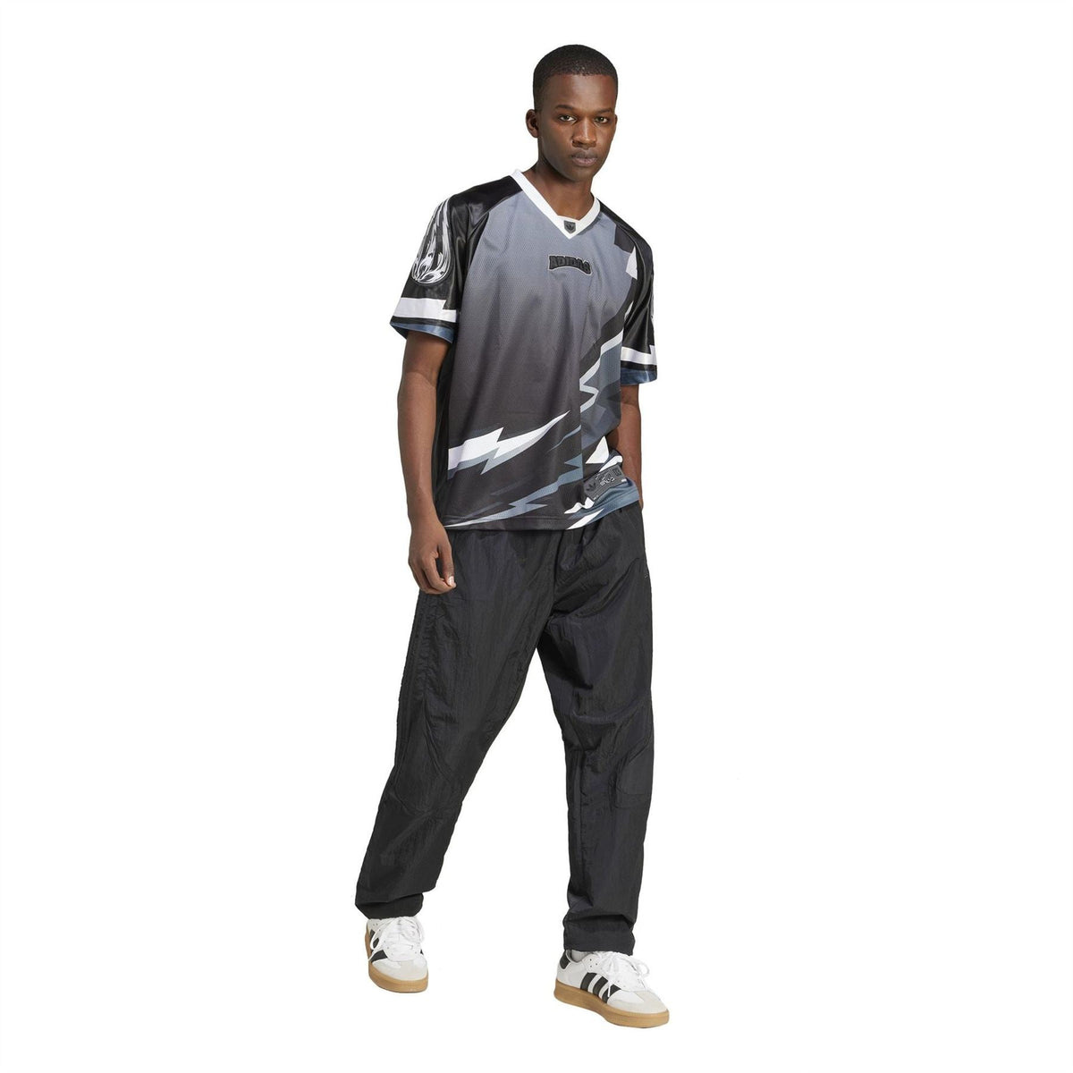 Black and gray team jersey with white lightning design, model wearing with dark pants
