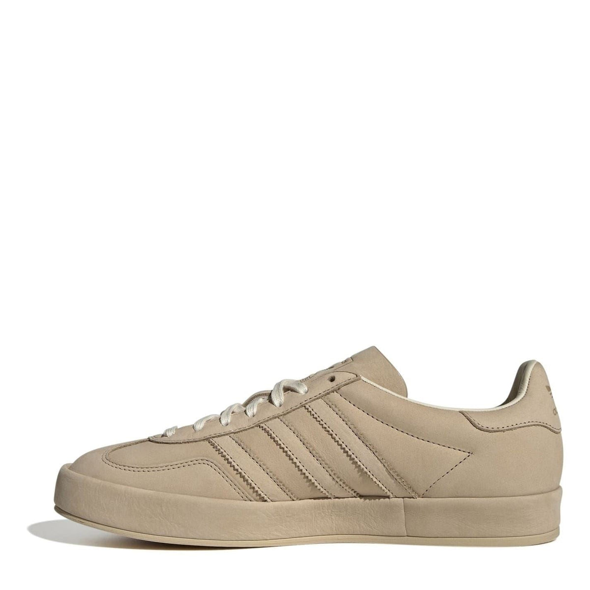 Beige suede lace-up low-top sneakers, side view with branded tongue label