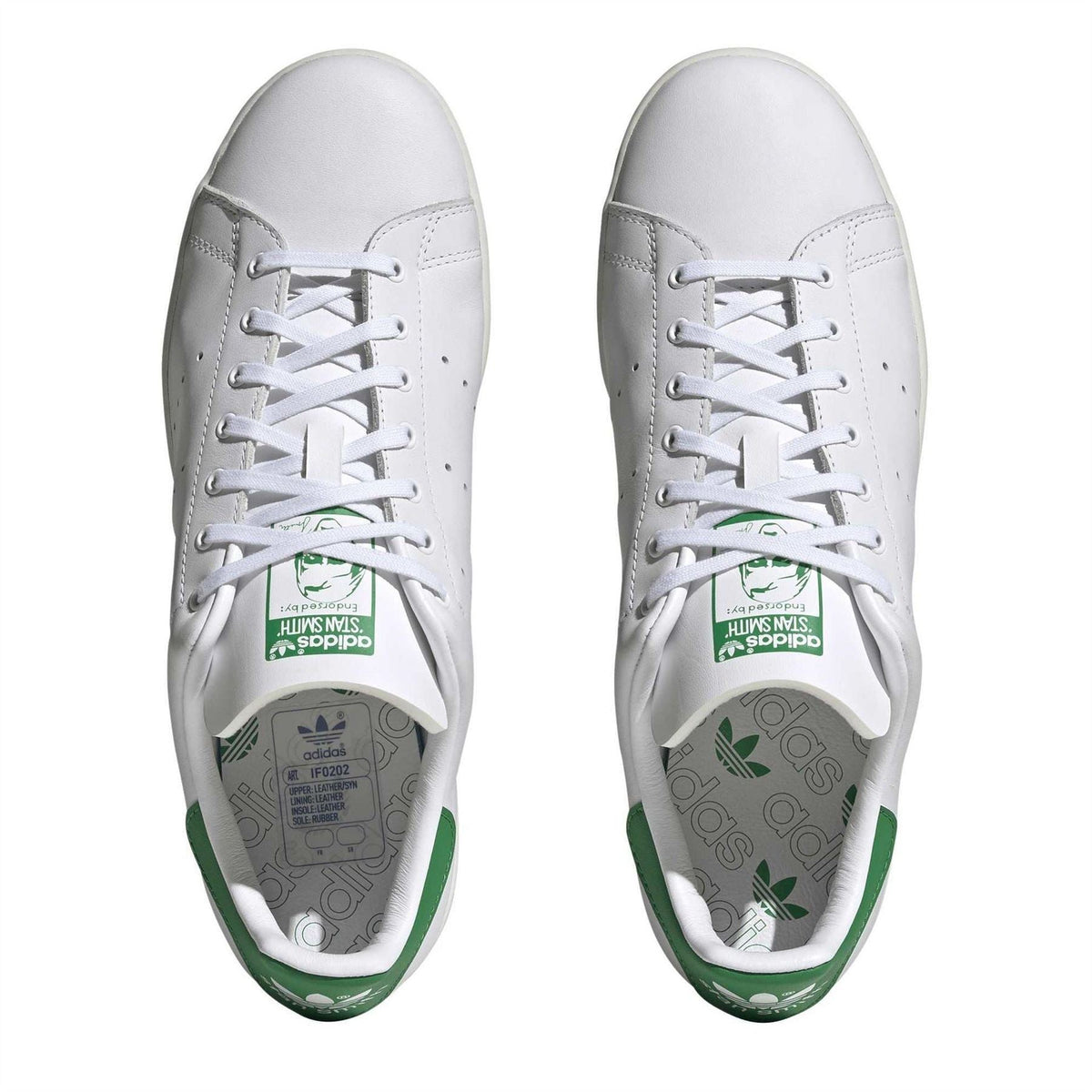 White sneakers with lace-up front and green insole branding detail
