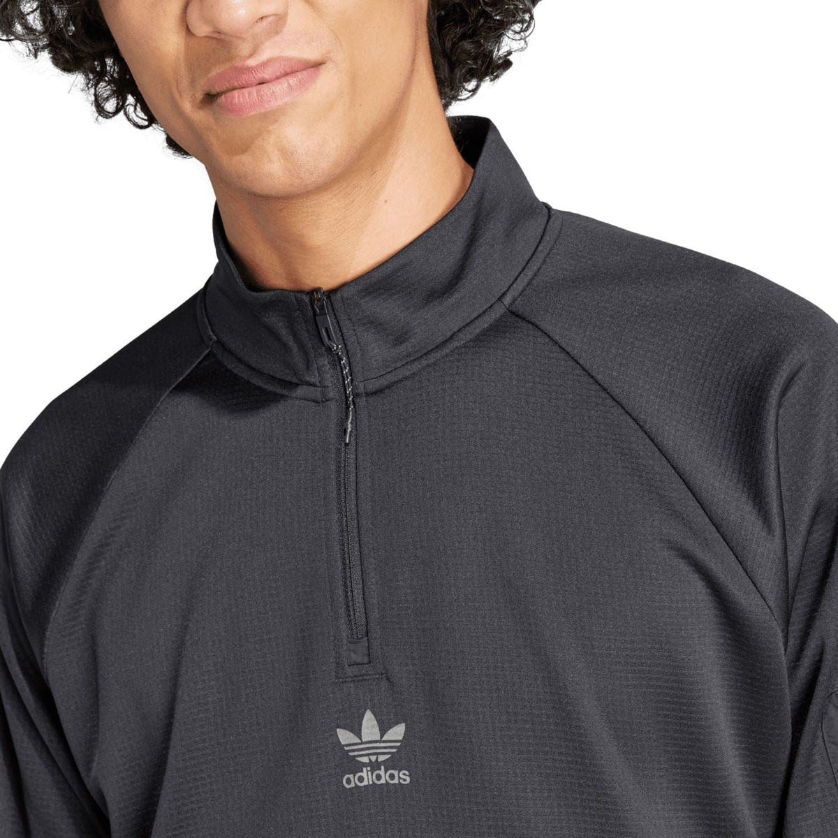 Black adidas quarter-zip top close-up of stand collar and chest logo