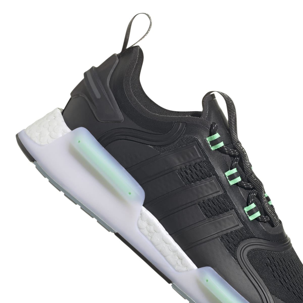 Black NMD_V3 trainers close-up side with green laces and white cushioned panels